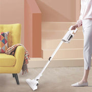 Cordless handheld vacuum cleaner in use on carpeted stairs.