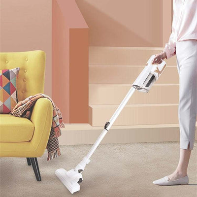 Cordless handheld vacuum cleaner in use on carpeted stairs.